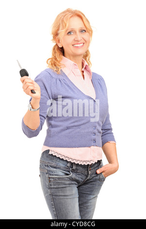 Smiling mature female holding a car key isolated on white background Stock Photo