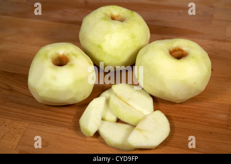 three peeled and one sliced bramley cooking apples Stock Photo