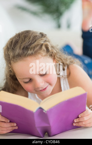 Girl resting on the sofa with book Stock Photo