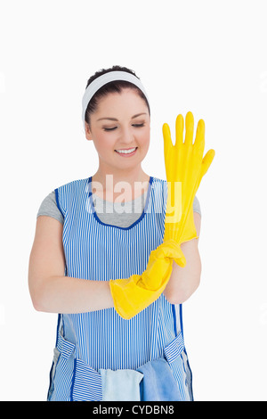 Cleaner woman putting on yellow gloves Stock Photo