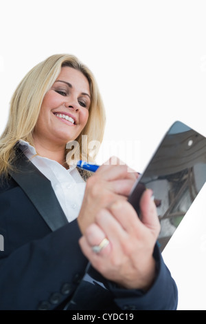 Happy business woman writing in the clipboard Stock Photo