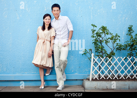 Chinese couple , standing before blue wall Stock Photo