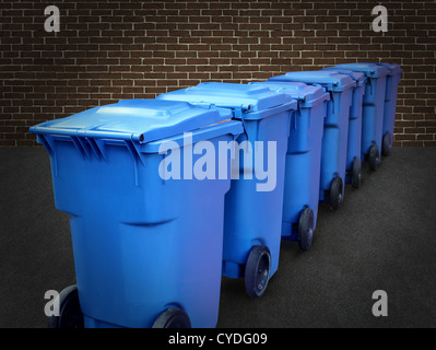 Recycle bins in a group made of commercial size blue plastic containers in a city street back alley against a brick wall as a conservation and recycling symbol of business environmental responsability. Stock Photo