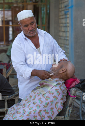 Uyghur Man Getting Shaved By A Barber At Serik Buya Market, Yarkand, Xinjiang Uyghur Autonomous Region, China Stock Photo