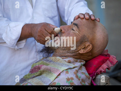 Uyghur Man Getting Shaved By A Barber At Serik Buya Market, Yarkand, Xinjiang Uyghur Autonomous Region, China Stock Photo