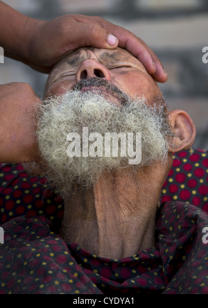 Uyghur Man Getting Shaved By A Barber At Serik Buya Market, Yarkand, Xinjiang Uyghur Autonomous Region, China Stock Photo