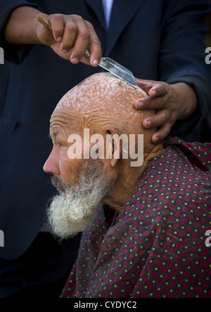 Uyghur Man Getting Shaved By A Barber At Serik Buya Market, Yarkand, Xinjiang Uyghur Autonomous Region, China Stock Photo