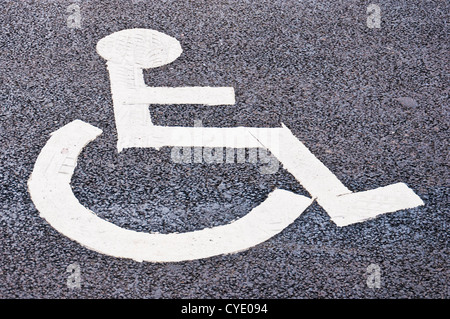 Disabled person sign painted on tarmac to show area of disabled parking Stock Photo