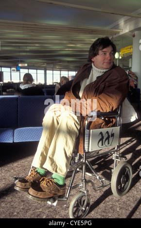 disabled/injured man in wheelchair at airport lounge Stock Photo