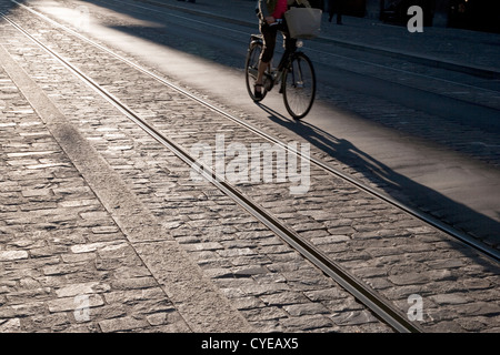Cyclist on Cobbled Street with Tram Tracks