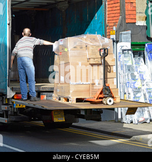 Lorry making a merchandise supplier delivery outside a High Street shop lowering to pavement using tailgate lift Sevenoaks Kent England UK Stock Photo