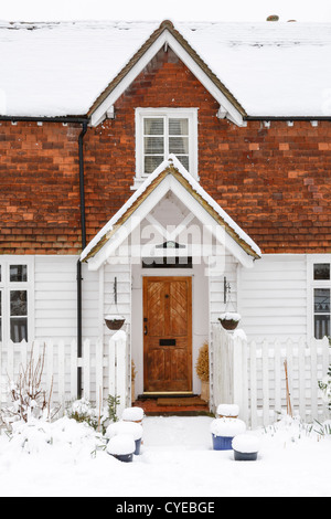 Front of clapboard home with snow on roof Stock Photo