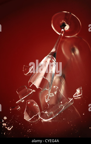 elegant wine glass broken on a red background Stock Photo