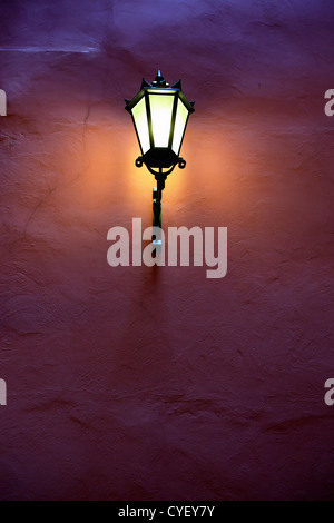 Old yellow light shining on the purple wall Stock Photo