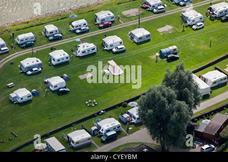 The Netherlands, Pannerden, Camping cars, campers and tents on campsite near Waal river. Aerial. Stock Photo