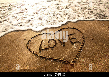 Love concept handwritten on sand Stock Photo