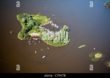 The Netherlands, Loosdrecht, Sailing boats and motor yachts anchored near island in Loosdrecht Lakes. Aerial.