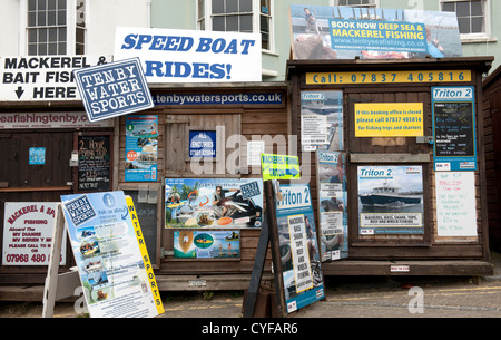 Booking offices and advertisements for boat trips, Tenby Harbour, Pembrokeshire, South Wales. Stock Photo