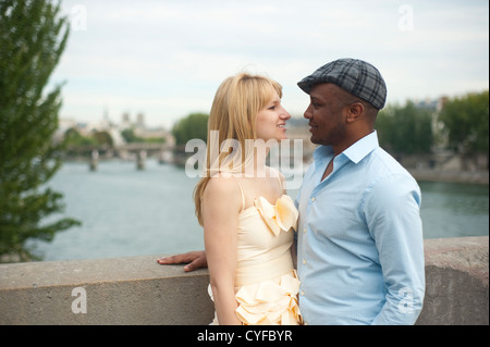 Paris, France - American mixed race young couple standing on  abridge over the Seine River Stock Photo
