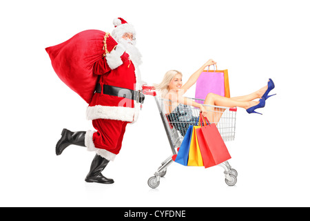 Santa Claus pushing a young woman in a shopping cart isolated on white background Stock Photo