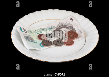 English Money on White Gold Rimmed Plate isolated on black background Stock Photo