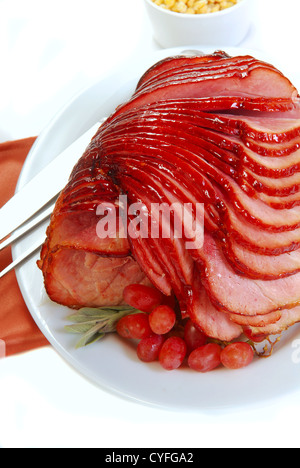 Delicious holiday meal with glazed baked spiral ham ready for Easter or Christmas dinner. Stock Photo