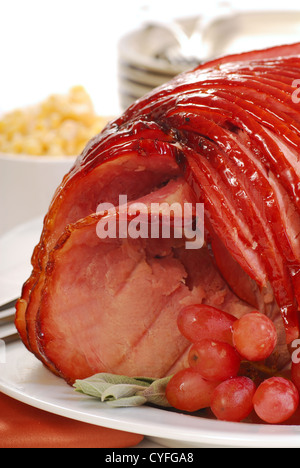 Delicious holiday meal with glazed baked spiral ham ready for Easter or Christmas dinner. Stock Photo