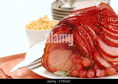 Delicious holiday meal with glazed baked spiral ham ready for Easter or Christmas dinner. Stock Photo