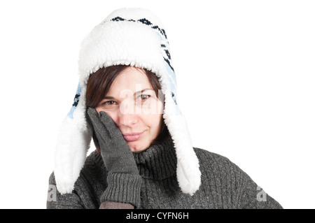 Woman with a toothache, wearing winter hat and gloves against a white background Stock Photo