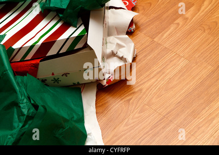 A pile of unwrapped gift boxes and ripped wrapping paper on the floor at Christmas time. Copy space was left on the right side. Stock Photo