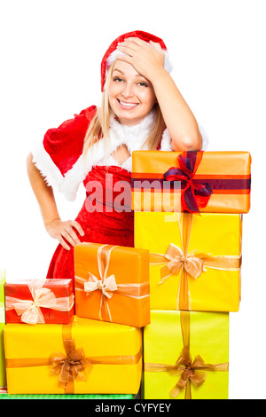 Young beautiful blond happy smiling woman in Santa costume surrounded by Christmas gift boxes, isolated on white background. Stock Photo