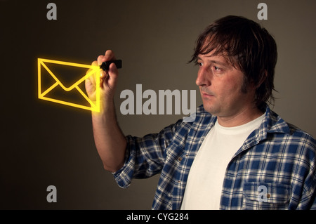 Young adult casual designer drawing an envelope with yellow pen marker in the air. Stock Photo