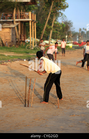 Sri Lankan men playing beach cricket on the beach in Weligama Bay, Sri Lanka. Stock Photo