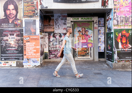 Young man walking past closed down bank branch of Caja Madrid, now part of Bankia, Madrid, Spain Stock Photo