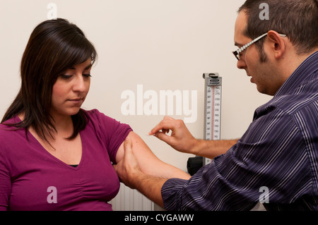 GP Doctor prepares to give a vaccination to a patient.