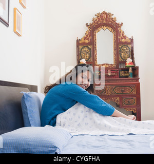 Woman sitting on the bed and smiling Stock Photo