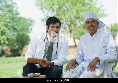 Doctor writing a prescription for a farmer Stock Photo