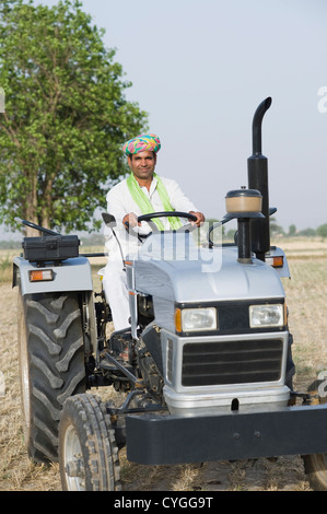 Portrait of Indian happy farmer ploughing the field manually in a day ...