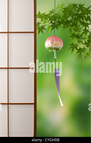 Wind chime and green maple leaves Stock Photo