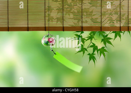 Wind chime and green maple leaves Stock Photo
