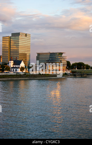 Alt St. Heribert church at Lufthansa offices at sunset, deutz, Cologne, Köln, Nordrhein-Westfalen, Germany reflected in  Rhine Stock Photo