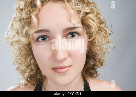Portrait of young blond curly woman on white studio background Stock Photo