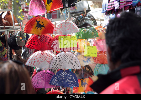 People tourists browsing Spanish flamenco style fans for sale, market stall, El Rastro, Madrid, Spain Stock Photo