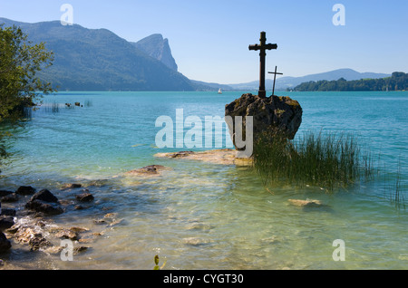 A cross on a rock on the banks of the Mondsee in Austria Stock Photo