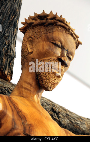 A wooden african statue of Jesus Christ on the cross with crown of thorns on his head, in a roman catholic chapel in Namibia Stock Photo