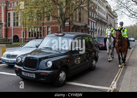 Black cab and mounted police officers on April 13, 2007 in London. Stock Photo