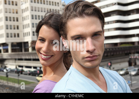 Couple stood outside of high-rise building Stock Photo