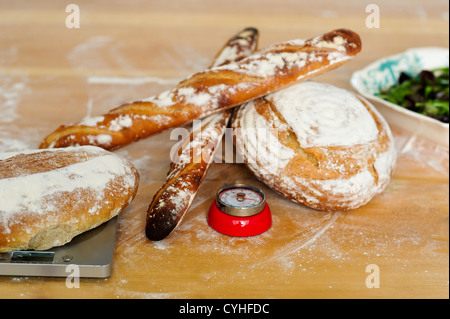 Baguettes and breads on wooden table. Closeup shot Stock Photo