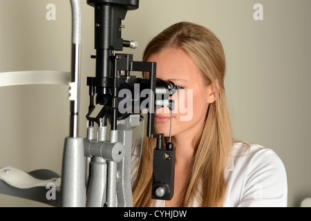 Female eye doctor using measurement equipment in office Stock Photo