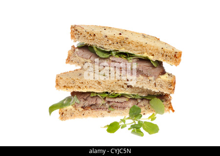 Roast beef and watercress sandwich on brown bread with watercress garnish isolated against white Stock Photo